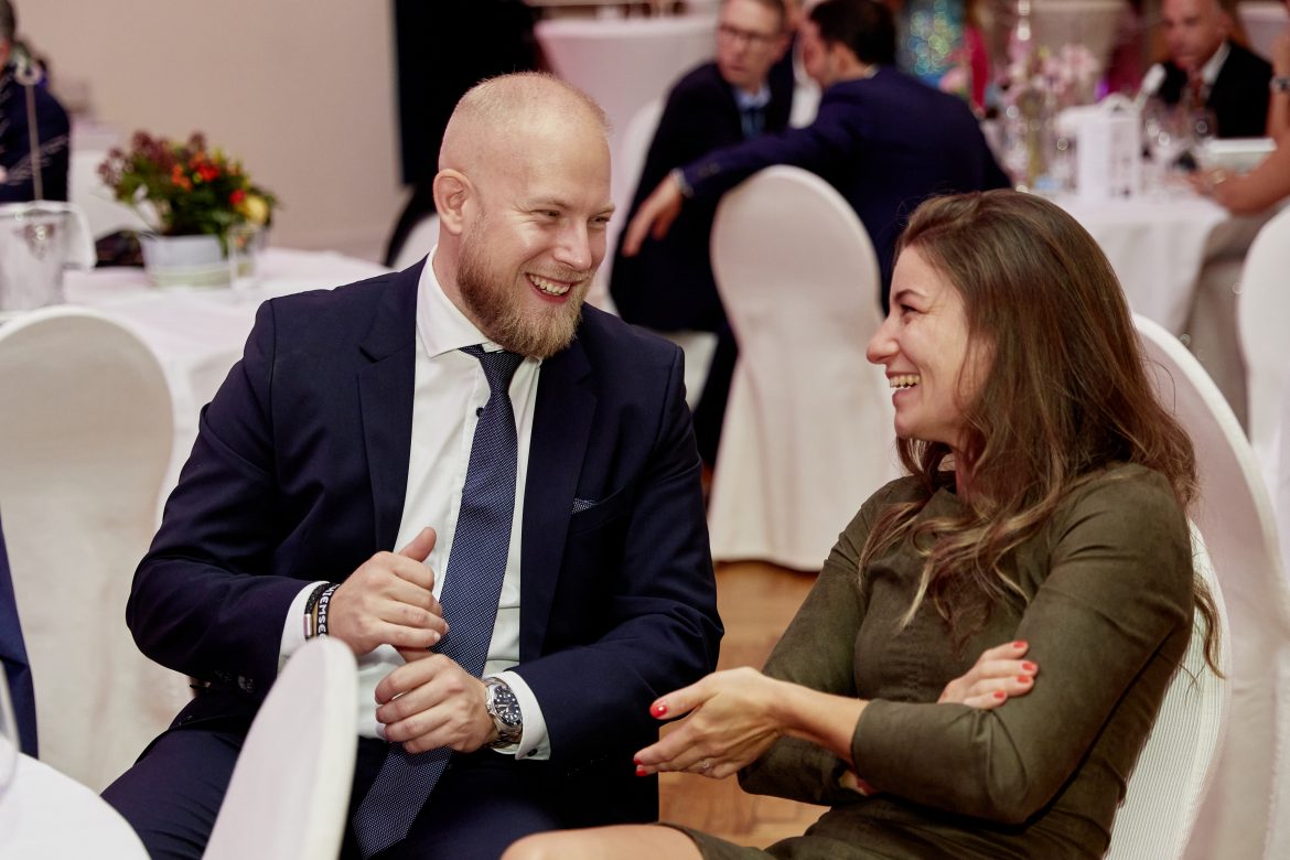 Zwei Gäste im Gespräch an einem Tisch